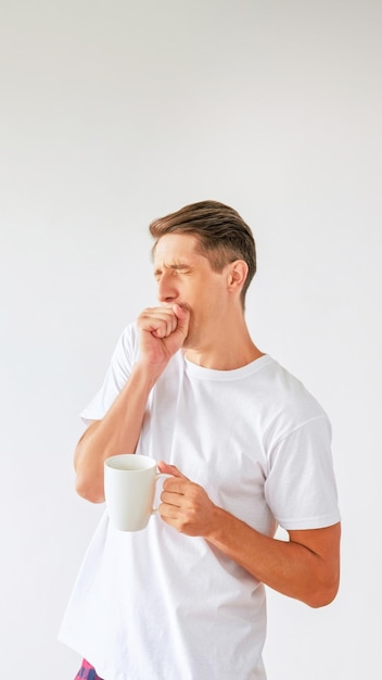 Rituale del caffè del mattino del ritratto dell'uomo assonnato che sbadiglia