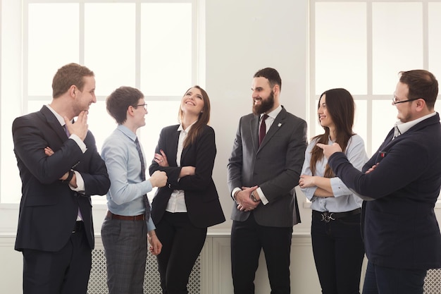 Riunione aziendale in ufficio, uomini d'affari che conversano, in piedi alla finestra. Lavoro di squadra, concetto di brainstorming, spazio di copia