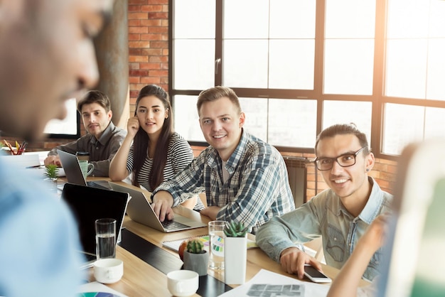 Riunione aziendale. Pubblico interessato che ascolta il rapporto del collega nero, copia spazio