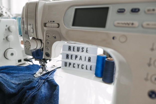 Riutilizzare il testo di riparazione upcycle su lavagna luminosa su macchine da cucire con vecchi vestiti in denim blue jeans