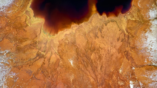 Riva del lago rossa tossica a cielo aperto di una miniera di rame abbandonata. Struttura della superficie mineraria, vista aerea