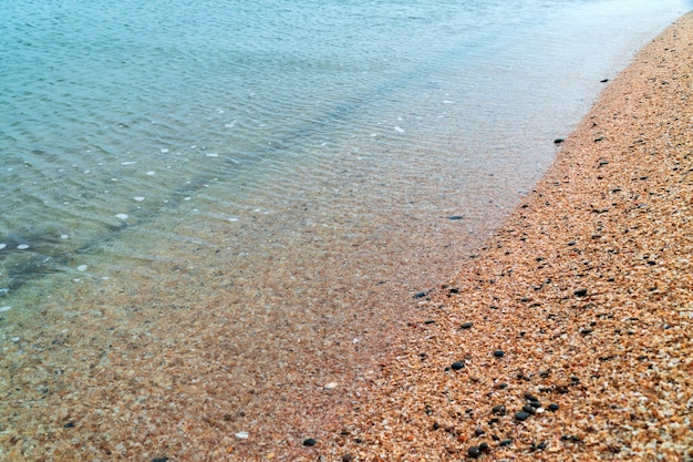 Riva del mare con acqua limpida e sabbia gialla