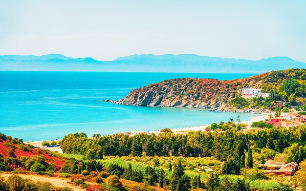 Riva della bellissima spiaggia di Villasimius presso la baia delle acque blu del Mar Mediterraneo sull'isola di Sardegna in Italia in estate. Regione Cagliari.