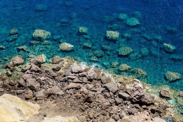 Riva rocciosa dell'oceano blu con acqua trasparente