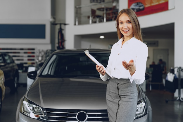 Rivenditore di auto felice bella giovane donna in showroom