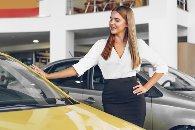 Rivenditore di auto felice bella giovane donna in showroom