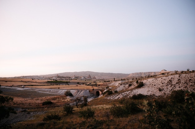 Rocce che sembrano funghi illuminate drammaticamente da un tramonto in Cappadocia, Turchia