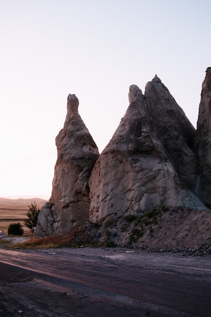 Rocce che sembrano funghi illuminate drammaticamente da un tramonto in Cappadocia, Turchia