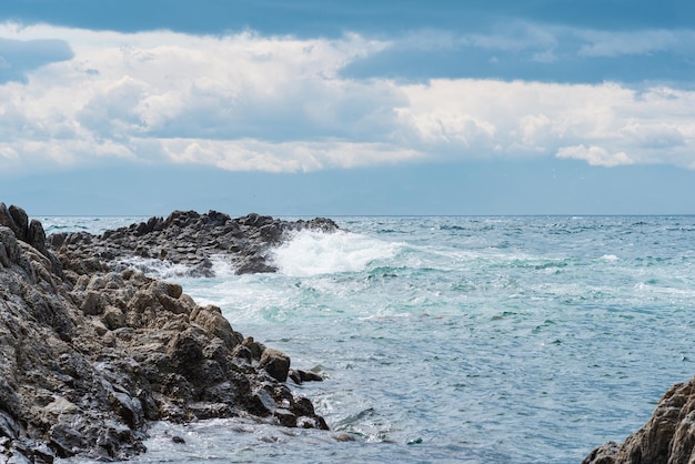 Rocce costiere costituite da basalto colonnare tra le onde del mare Cape Stolyuchy sull'isola di Kunashir