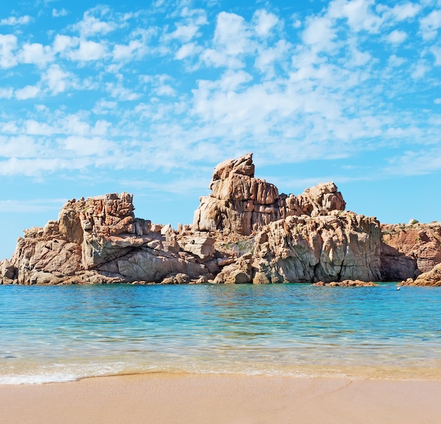 Rocce e mare blu sotto un cielo nuvoloso