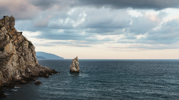 Rocce e mare con cielo serale.