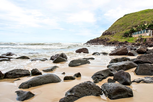 Rocce nella sabbia e nel mare sudamericano Spiaggia di Torres Rio Grande do Sul Brasile