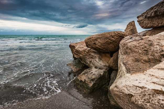 Rocce sulla spiaggia con un cielo nuvoloso sullo sfondo