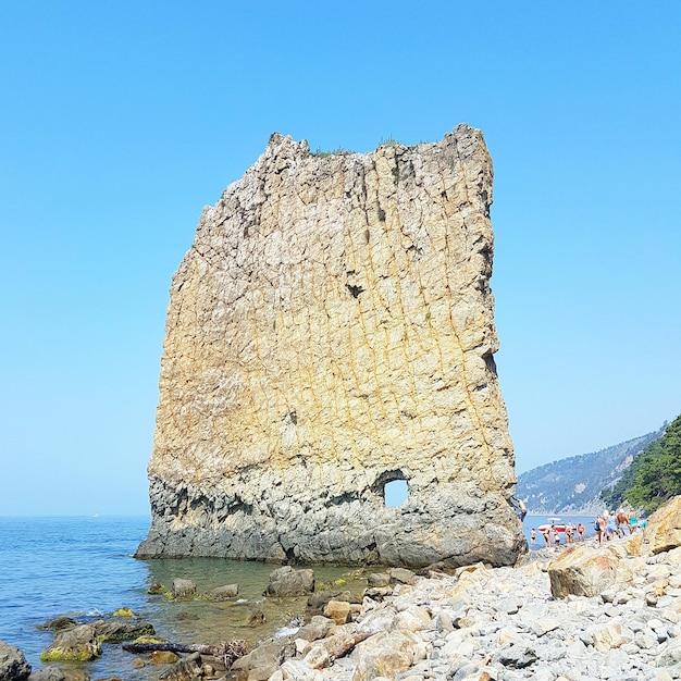 Roccia a vela sul mare nero contro un cielo blu limpido