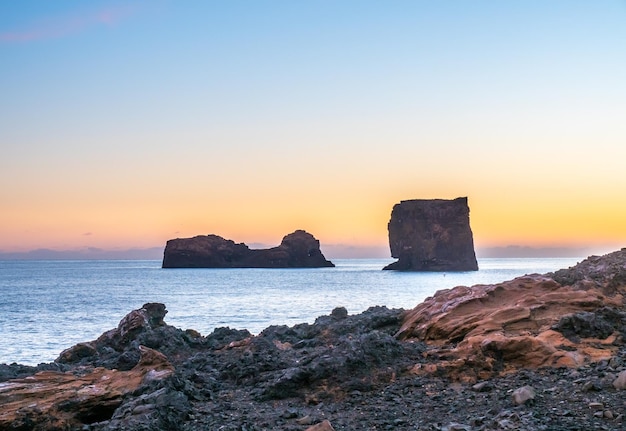 Roccia di larva in spiaggia e piccole isole vicino alla costa dell'arco di Dyrholaey in Islanda vicino alla città di Vik