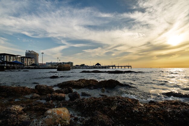 Roccia sul mare con sfondo urbano