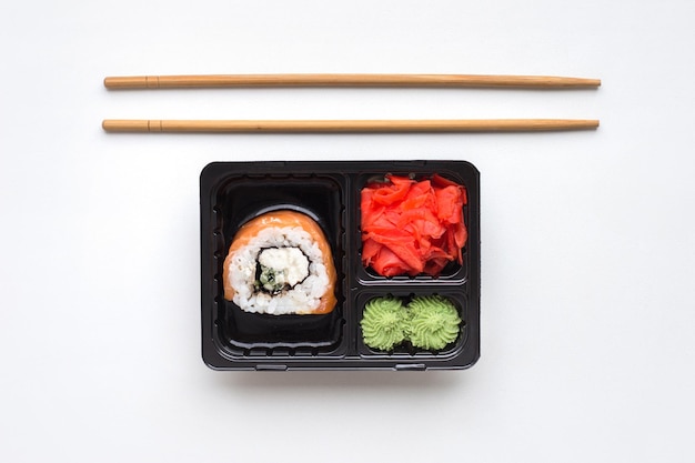 Roll wasabi nori in una ciotola di plastica isolata su sfondo bianco vista dall'alto