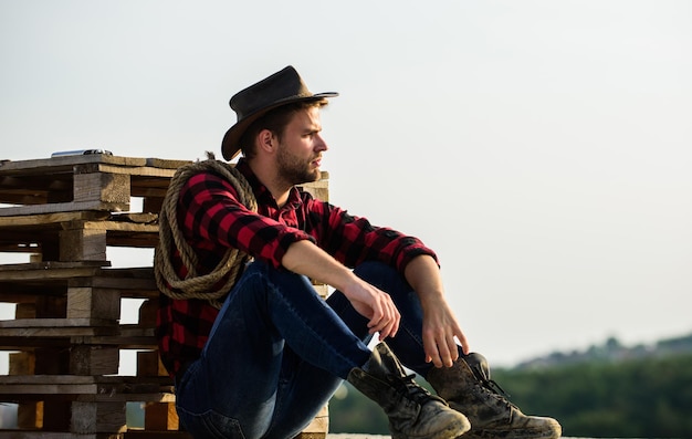 Romanticismo della cultura occidentale Contadino con cappello sedersi relax Contadino godersi la vista dalla sua fattoria Umore pacifico Guardare il tramonto Contadino cowboy bell'uomo che si rilassa dopo una dura giornata di lavoro al ranch