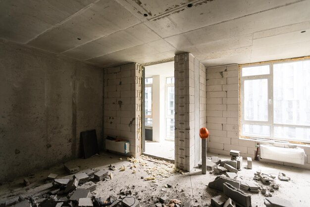 Rompere il muro per lavori di ristrutturazione e costruire la porta d'ingresso dell'edificio. Carriola con mattoni rotti nella costruzione del sito.