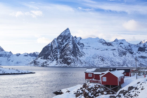 Rorbu tradizionale norvegese in legno per stare sulla riva del fiordo e delle montagne in lontananza. Isole Lofoten. Norvegia. viaggio nel mondo