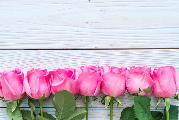 rosa rosa in vaso su fondo di legno