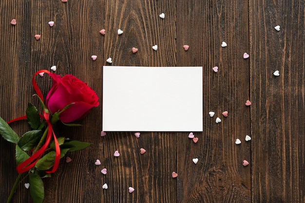 Rosa rossa con cartolina su sfondo di legno Cartolina di San Valentino felice Concetto di amore per la festa della mamma o San Valentino Cartolina di San Valentino con spazio per il testo