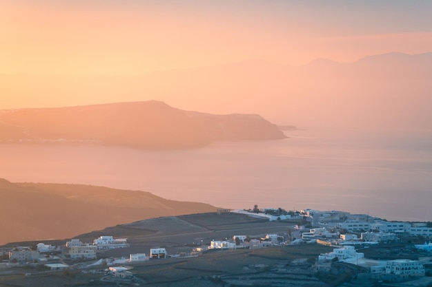 Rosa tramonto nebbioso sull'isola di Santorini in Grecia Vista sul mare e sulle isole Bellissimo paesaggio marino estivo Famosa destinazione di viaggio