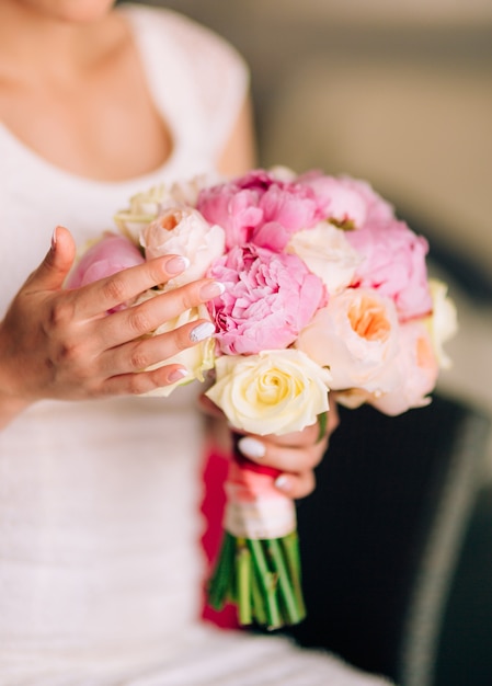 Rose e peonie nuziali nelle mani della sposa matrimonio