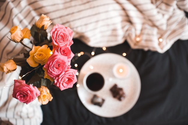 Rose fresche con una tazza di tè a letto. Buon giorno.