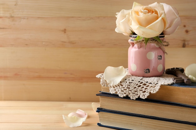 Rose fresche con vecchi libri su fondo di legno. Concetto d'epoca