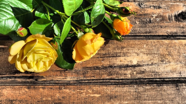 Rose gialle su sfondo di legno Bellissimo bouquet di 3 rose su un tavolo di legno scuro Biglietto di auguri con 8 marzo Festa della mamma o San Valentino