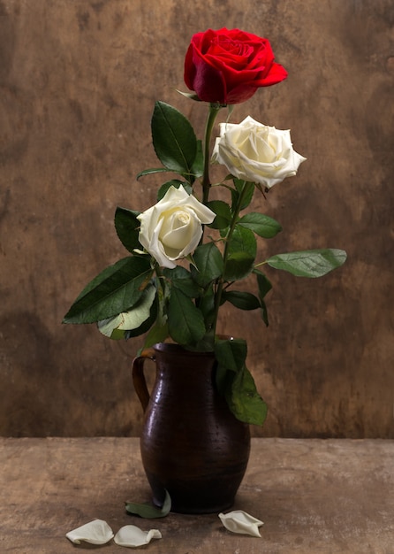 Rose in un vaso su uno sfondo di legno