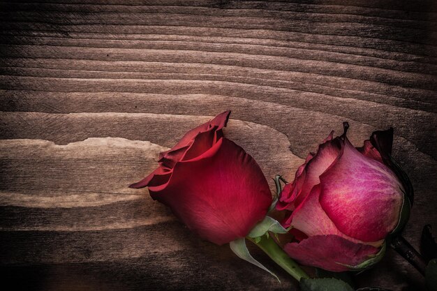 Rose naturali rosse sul concetto di feste del bordo di legno