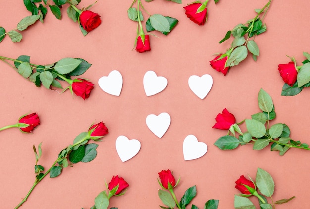 Rose rosse e forme di cuore sul rosa