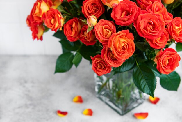 Rose rosse in un vaso di vetro sul tavolo