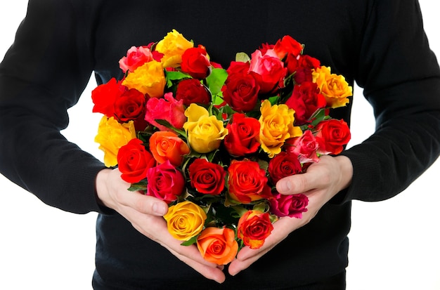 Rose rosse. mani d'uomo con bouquet di fiori colorati a forma di cuore