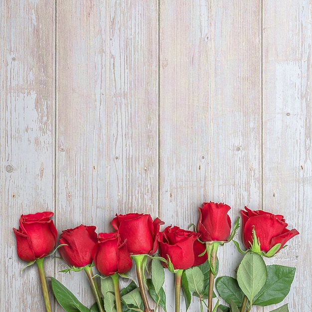 Rose rosse nella parte inferiore di una parete in legno Layout per inviti di cartoline per San Valentino