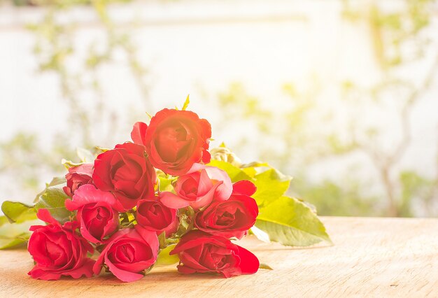 rose rosse sul pavimento di legno