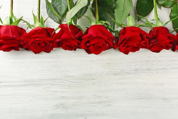 Rose rosse sul tavolo di legno