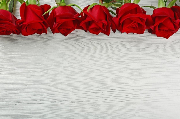 Rose rosse sul tavolo di legno