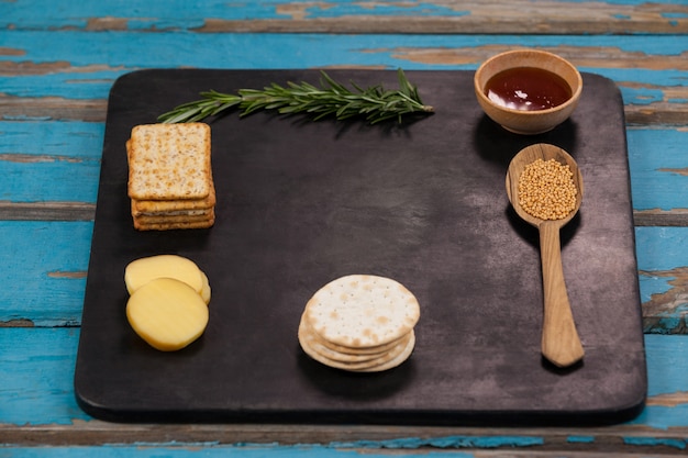 Rosmarino, formaggio e biscotti con spezie su lavagna