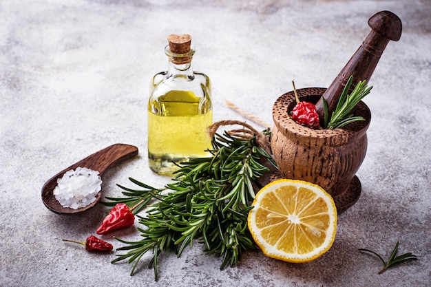 Rosmarino, sale, limone, olio e pepe. Varie spezie su sfondo concreto. Messa a fuoco selettiva