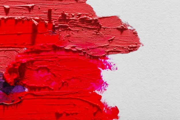 Rossetto colorato sbavato su bianco, primo piano