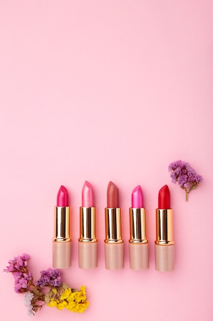 Rossetto con bellissimi fiori sul tavolo rosa con copia spazio.