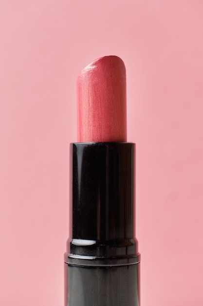 Rossetto cosmetico su uno sfondo rosa