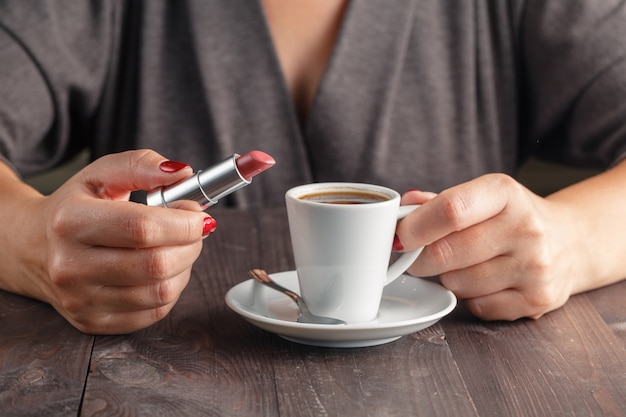 Rossetto tra le mani. Cosmetici.