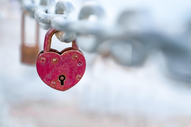 Rosso a forma di cuore appeso alla catena del ponte, simbolo dell'amore, copia spazio