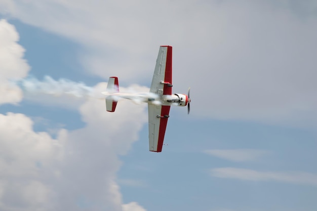 Rosso - bianco getti di fumo dell'aereo in volo in un primo piano del cielo blu