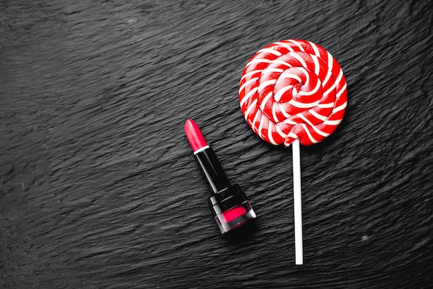 rosso rotondo Lollipop su uno sfondo nero con una texture vicino al rossetto dolce