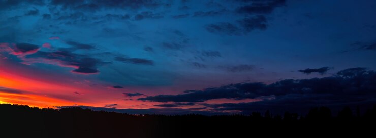 Rosso tramonto soleggiato con nuvole temporalesche all'orizzonte